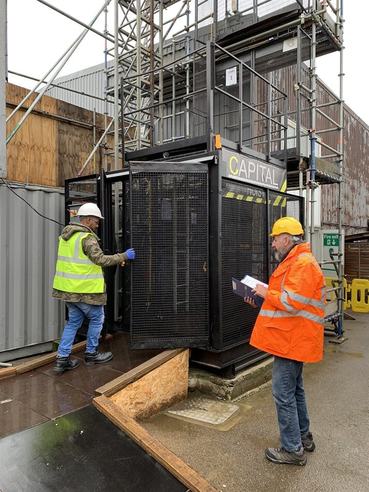 Capital Hoist personnel completing equipment checks beside a construction hoist